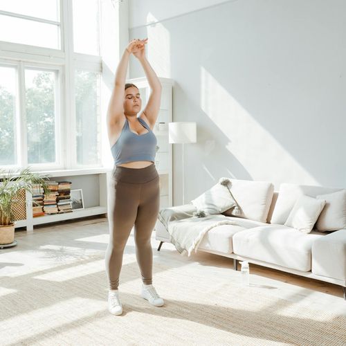 Healthy person stretching in a bright living room environment